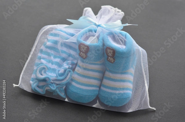 Fototapeta Blue colour newborn booties and mitten on black background