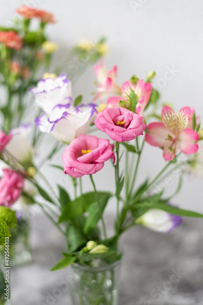 Obraz Colorful flowers composition over grey background with copy space. Fresh cut flowers for decoration home. Flower arrangement in a vase for home. Women's Day and spring time flower background