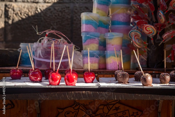 Fototapeta Candy apple, toffee apples, caramelized apples on a mobile stall in a medieval market