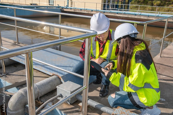 Fototapeta Environmental engineers work at wastewater treatment plants,Water supply engineering working at Water recycling plant for reuse,Technicians and engineers discuss work together.