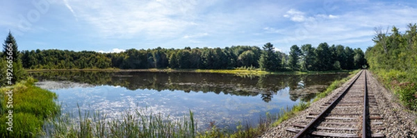 Obraz Rural New York countryside scenery showing old abandoned train tracks next to a pond in the woods