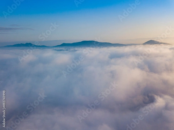 Fototapeta Flight over fog in Ukrainian Carpathians in summer. Mountains on the horizon. Aerial drone view.