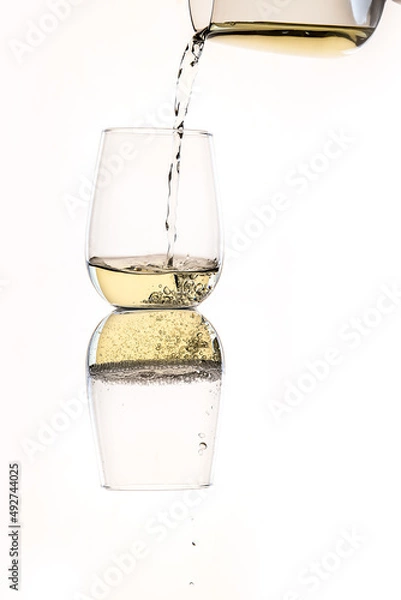 Fototapeta white wine or apple juice in a transparent glass isolated over white background