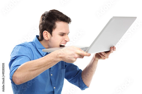 Fototapeta Man biting a laptop in frustration