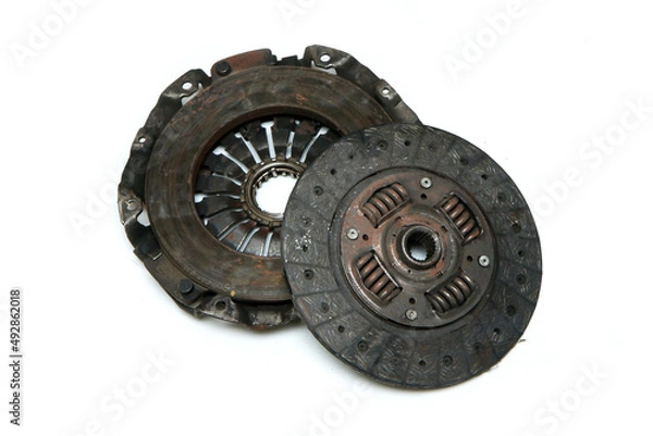 Fototapeta The old rusty used clutch from the car engine isolated in a white background. Has to be changed for new one. 