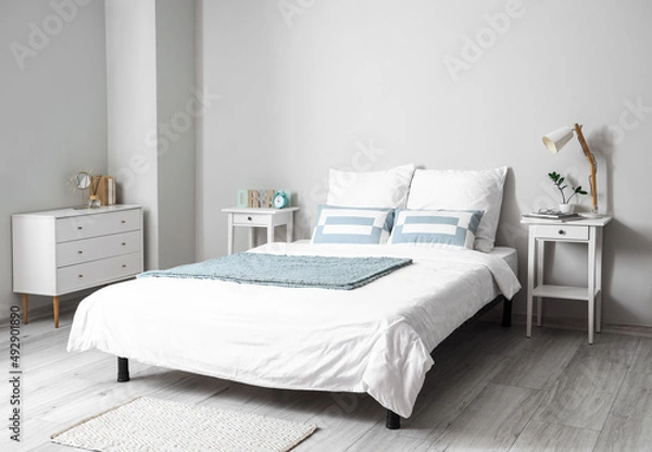 Obraz Comfortable bed with tables in interior of room