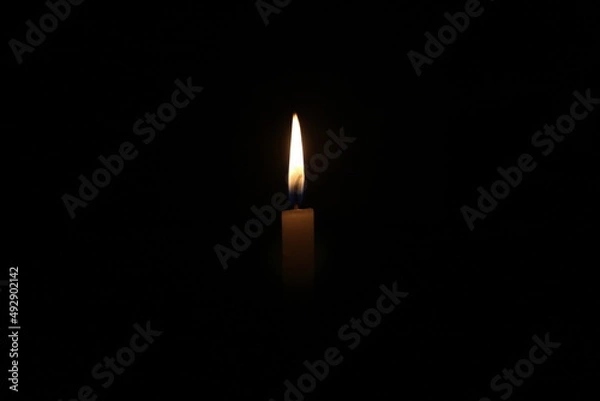 Obraz a candle is burning brightly in the dark