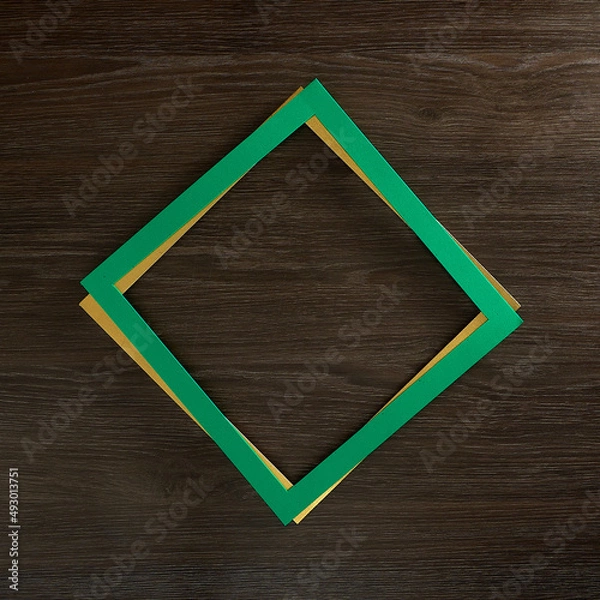 Fototapeta Green frame on gold frame. Rhomboid shape. Dark wood background. Text space. Top view. Minimal style.