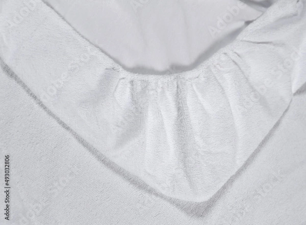 Fototapeta Mattress top corner with sewn-in elastic band for a good fit on the mattress and a comfortable sleep. White fabric for mockup overlays of any design. Home textile for the bedroom