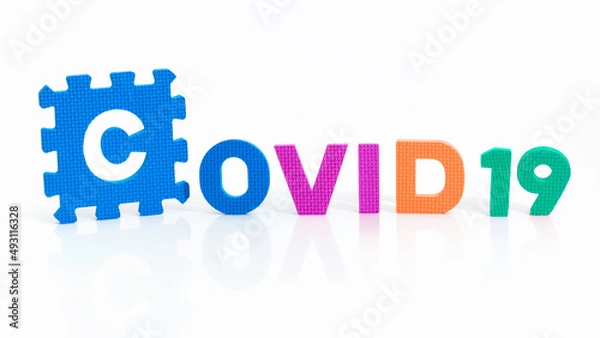 Fototapeta Close up on the word Covid 19 written in 3 different colors. Coronavirus pandemic and prevention vaccination campaign.