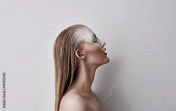 Fototapeta Be whatever you feel like. Shot of a beautiful woman wearing face paint and red lipstick against a plain background.