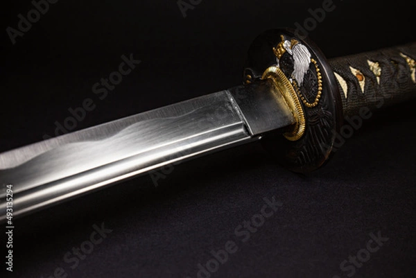 Fototapeta Japanese katana samurai sword with a pattern on a black background