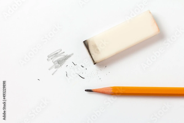 Fototapeta Eraser with traces of dust and a pencil on a white sheet