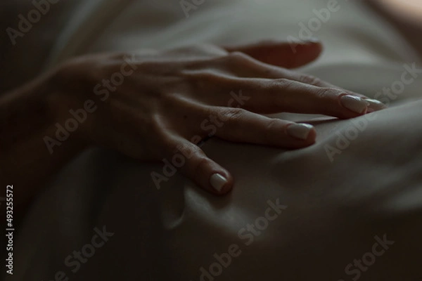 Fototapeta Close-up of a woman's hand. Gentle and sensual movement. Female attractiveness and temptation. Soft focus and beautiful bokeh.