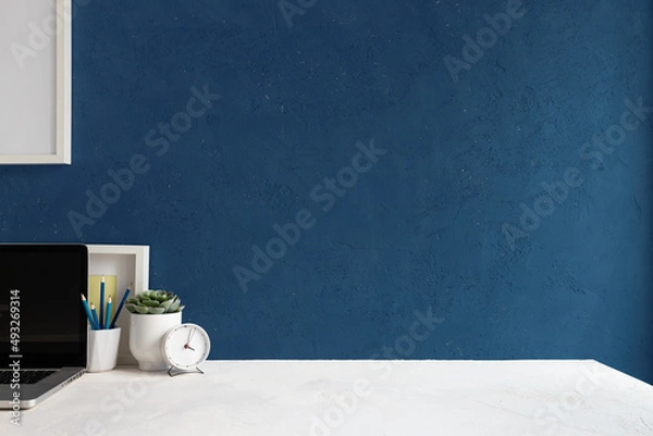 Obraz Office table, empty desk with supplies and blue wall copy space.	