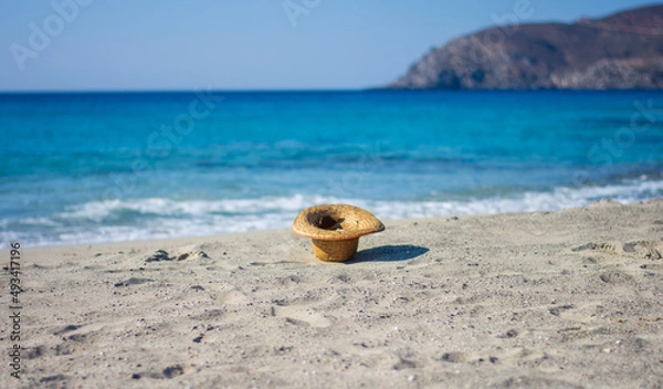 Fototapeta a hat on the beach blown by the wind