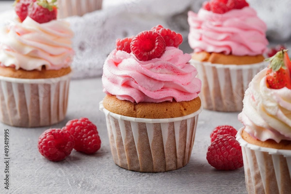 Fototapeta Pink cupcakes with cream and fresh berries