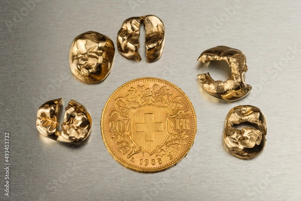 Fototapeta Eine schweizer Goldmünze umringt von goldenen Zähnen (Zahngold / Goldkronen) / Vreneli Schweiz 20 FR - Goldvreneli 