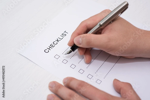 Obraz Close-up Of Person's Hand Marking On Checklist Form