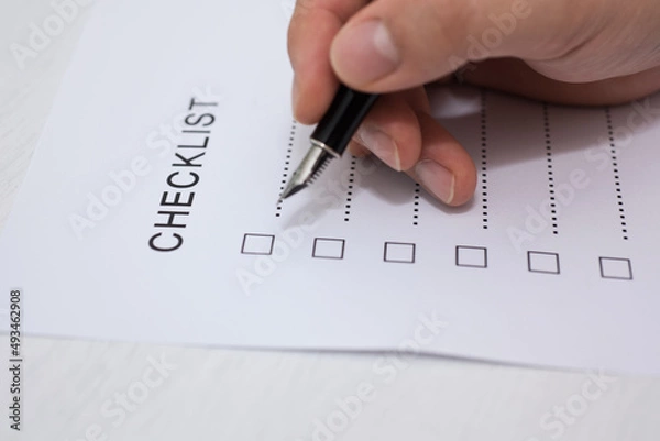 Obraz Close-up Of Person's Hand Marking On Checklist Form