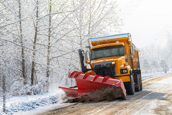 Obraz A Yellow Township snowplow removes the snow that fell last night on Seward Road in Windsor in Upstate NY.
