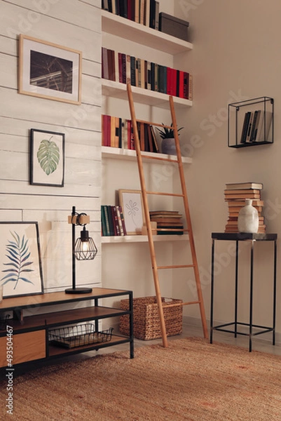 Fototapeta Home library interior with modern furniture and collection of different books on shelves