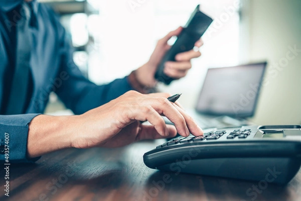 Fototapeta businessman dialing desk phone in the office. Telephone dialing ,contact and customer service.