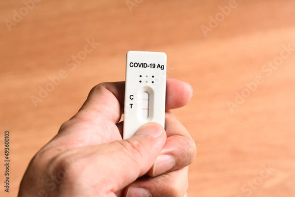 Fototapeta Slowly checking ATK Antigen Rapid Test Kit with Positive Result Detected of Covid-19 Virus on hand	