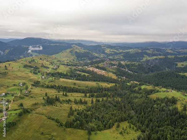 Fototapeta Green slopes of Ukrainian Carpathian mountains in summer. Cloudy morning, low clouds. Aerial drone view.