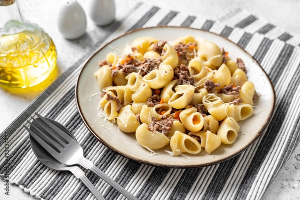 Obraz Pasta Pipe Rigate with stew In Bianco in a plate on a gray culinary background. Traditional Italian pasta with ground beef on the kitchen table closeup