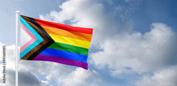 Obraz Progress LGBTQ rainbow flag waving in the wind at cloudy sky. Freedom and love concept. Pride month. activism, community and freedom Concept. Copy space