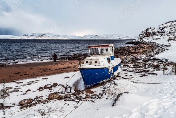 Fototapeta Old ship moored by the sea with the mountains in the background