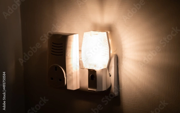 Fototapeta Close up of a night light plugged into a wall in a house