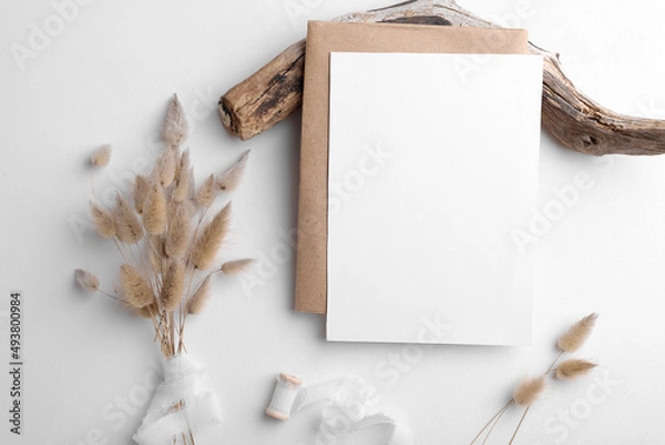 Obraz Wedding invitation card mockup 5x7 on white background with envelop and boho decor. Baby shower o bridal shower mockup. Minimal bohemian style vertical blank card mockup, thank you card, greeting card