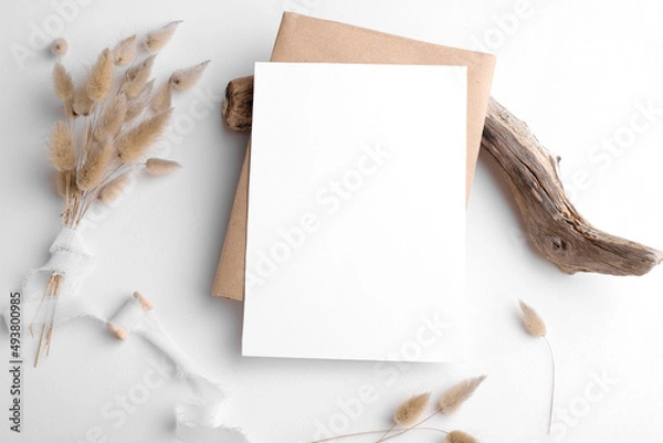 Obraz Wedding invitation card mockup 5x7 on white background with envelop and boho decor. Baby shower o bridal shower mockup. Minimal bohemian style vertical blank card mockup, thank you card, greeting card