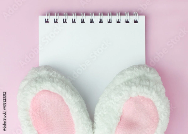 Obraz Easter hat bunny ears on pink background on the notebook with copyspace