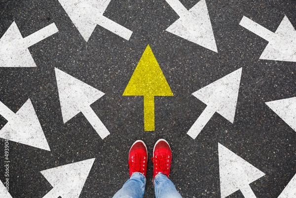 Fototapeta Person standing on the road to future life with many direction sign point in different ways and only yellow one. Decision making is very hard, but you have a choice and right way