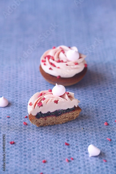 Fototapeta Shortbread Cookie with Blackcurrant Jam Filling and Whipped Ruby Chocolate Cream sprinkled with Freeze Dried Raspberries, on a light purple background.