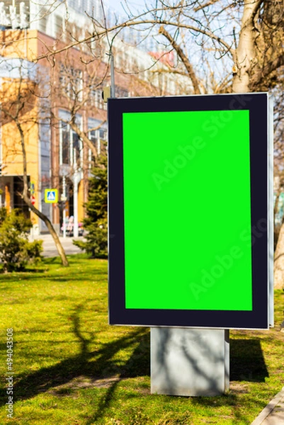 Fototapeta Green screen billboard mockup near footpath on blurred street background