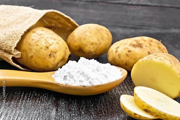 Obraz Starch potato in spoon on black board