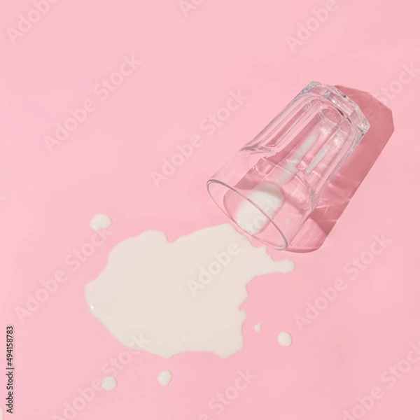 Fototapeta Creative layout with  glass of spilled milk on pastel pink background. 80s, 90s retro aesthetic style romantic concept. Minimal fashion food idea.