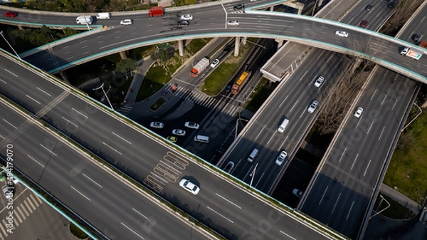 Fototapeta Top up aerial drone view of elevated road and traffic junctions in Chinese metropolis city Chengdu during sunny day. Modern construction design of traffic ways to avoid traffic jams. Few vehicles.