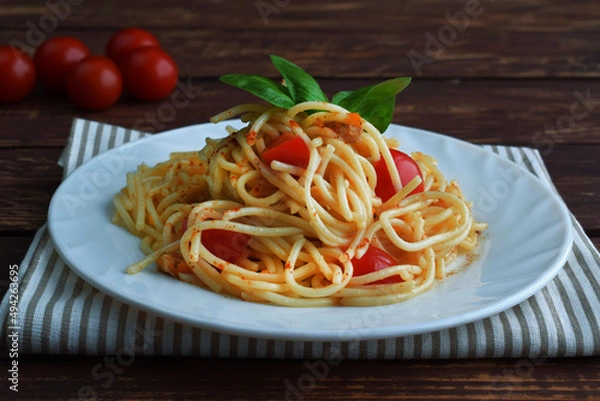 Obraz Spaghetti pasta with tomatoes and basil on a wooden table.