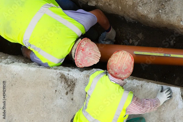 Obraz construction workers for repair water  and  sewer pipes in construction site