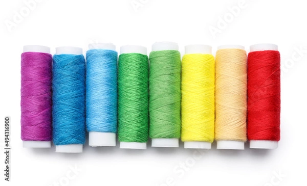 Fototapeta Multicolored sewing thread spools on white background