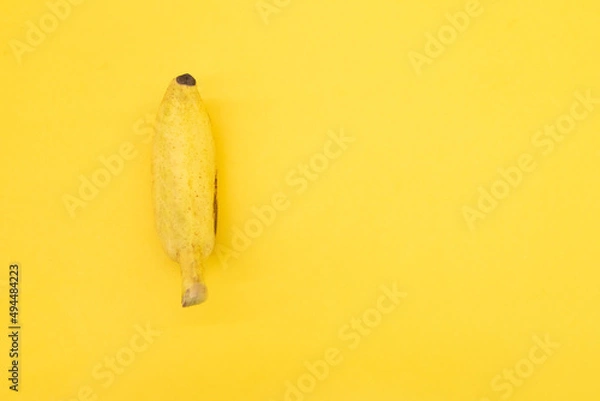 Fototapeta single bananas isolated on yellow background, top view