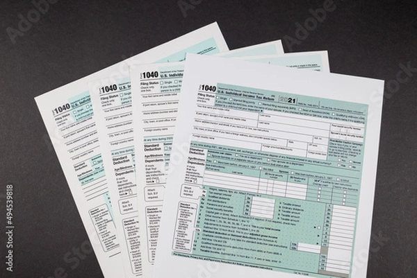 Fototapeta Tax forms 1040 on a black background.