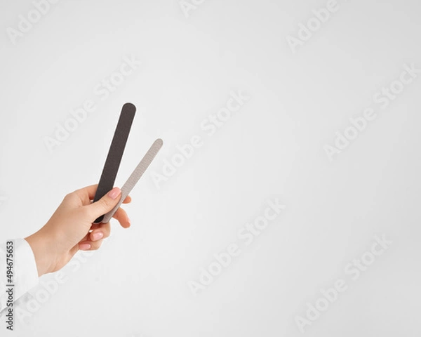 Obraz a hand with a nail file on white background with (copy space, horizontally)