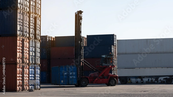 Fototapeta forklift working in the container cargo yard port loading cargo tank  logistic service and transportation concept.