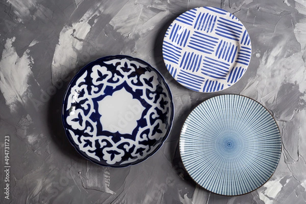 Obraz Three plates with patterns on a gray background top view
